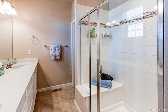 bathroom featuring a shower with door, vanity, and tile patterned flooring