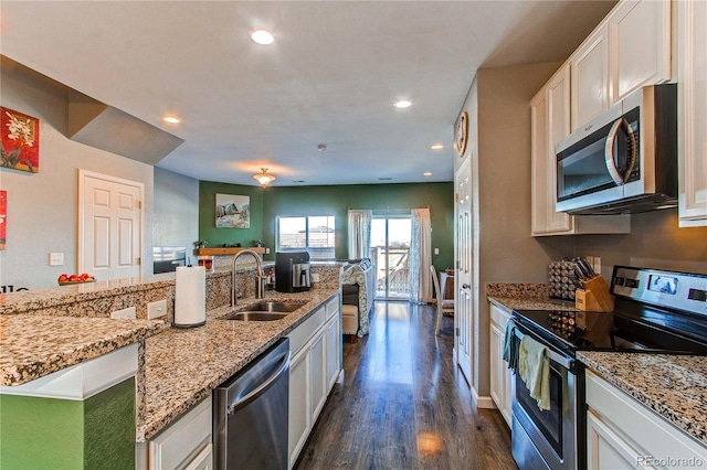 kitchen featuring sink, white cabinetry, dark hardwood / wood-style flooring, stainless steel appliances, and light stone countertops