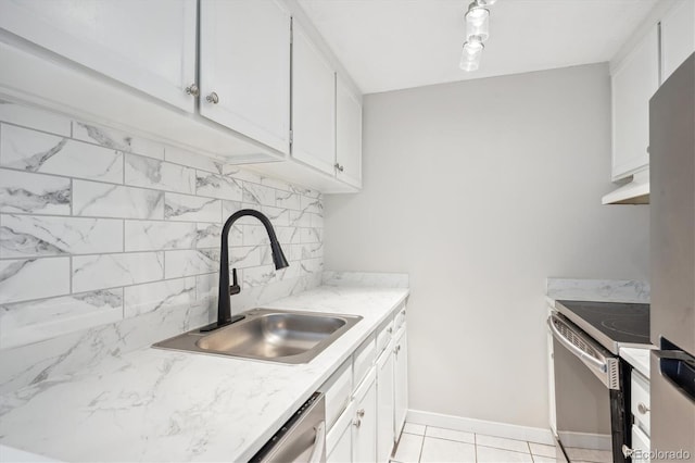 kitchen featuring range, tasteful backsplash, white cabinetry, and sink