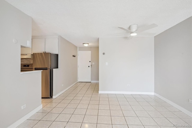 spare room featuring light tile patterned floors, a textured ceiling, and ceiling fan