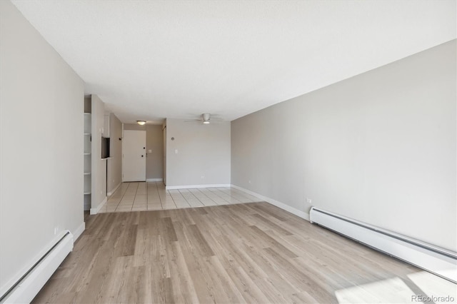 unfurnished room with ceiling fan, light hardwood / wood-style flooring, and a baseboard heating unit