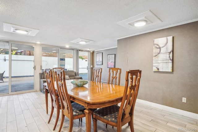 dining area with a textured ceiling, crown molding, and french doors