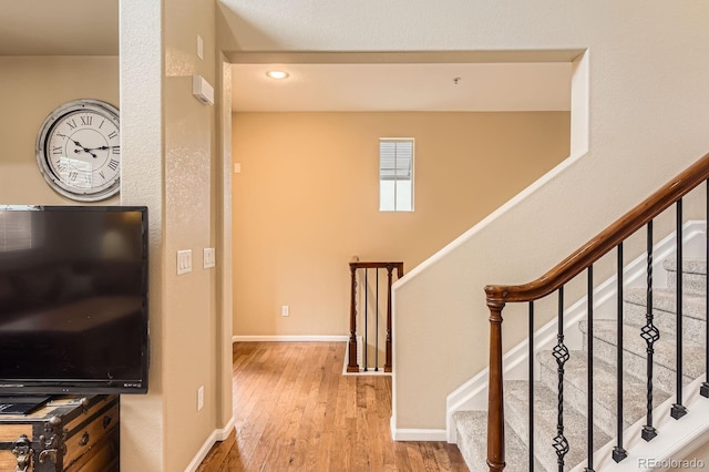 stairs with wood finished floors and baseboards