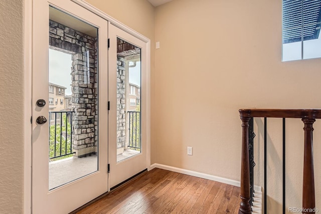doorway to outside with wood-type flooring, plenty of natural light, and baseboards