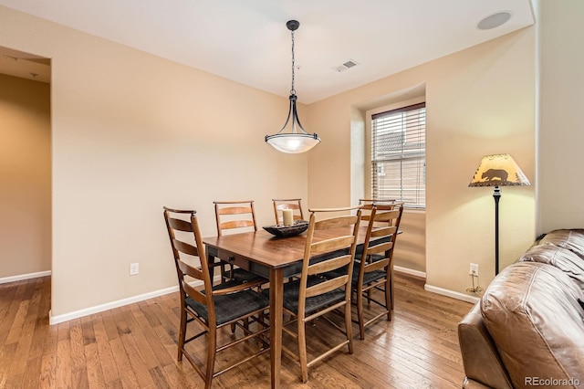 dining area featuring wood-type flooring and baseboards