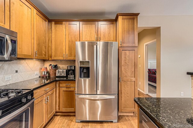 kitchen with stainless steel appliances, decorative backsplash, and brown cabinets