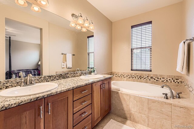 full bathroom featuring plenty of natural light, a bath, tile patterned floors, and double vanity