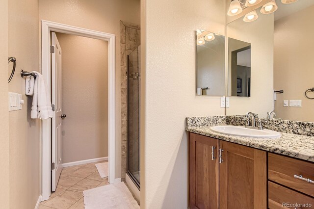 full bathroom with vanity, a stall shower, and tile patterned floors