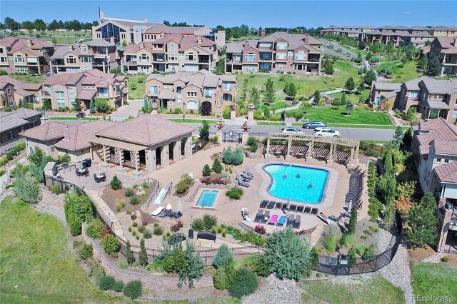 aerial view of property's location featuring a pool area and nearby suburban area