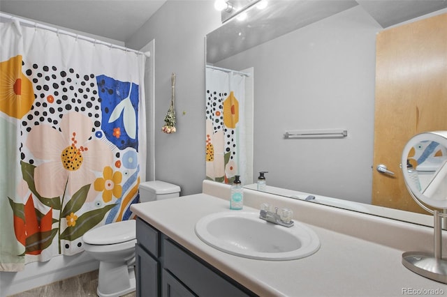 full bathroom featuring hardwood / wood-style flooring, vanity, shower / tub combo, and toilet