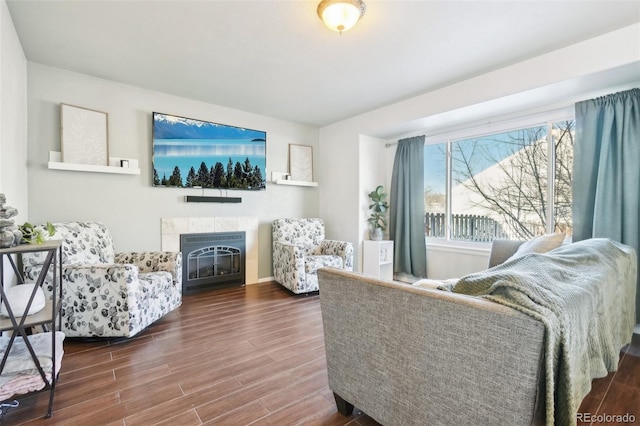 living room with dark hardwood / wood-style floors and a tiled fireplace