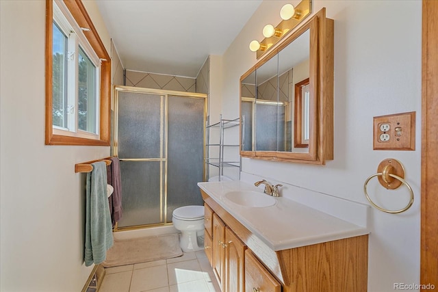 full bath with a stall shower, vanity, tile patterned floors, and toilet