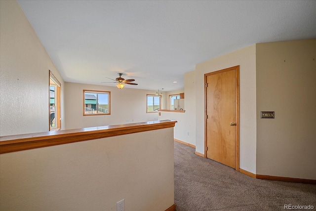 hallway with dark carpet and baseboards