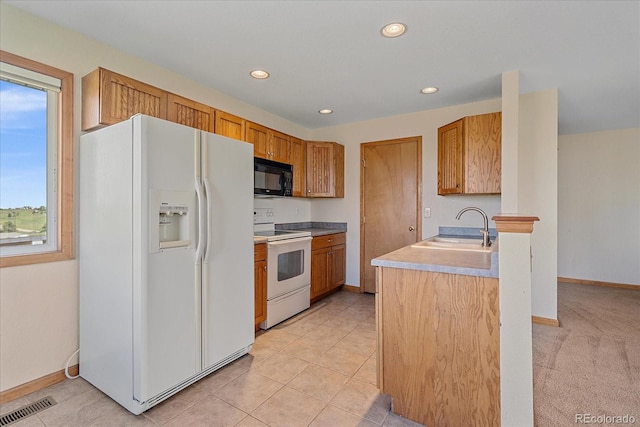 kitchen with white appliances, a sink, recessed lighting, baseboards, and light countertops