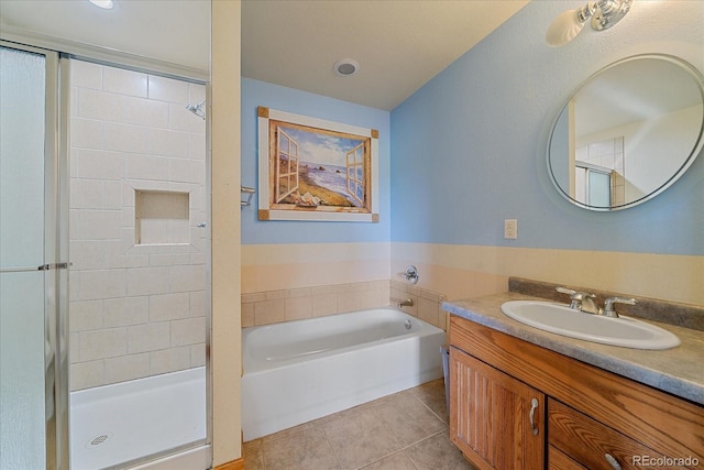 bathroom featuring tile patterned flooring, a stall shower, vanity, and a garden tub