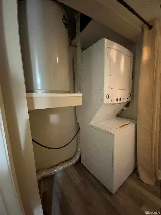 clothes washing area featuring stacked washing maching and dryer and hardwood / wood-style floors