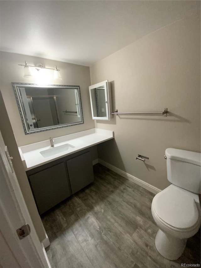 bathroom featuring hardwood / wood-style flooring, vanity, and toilet