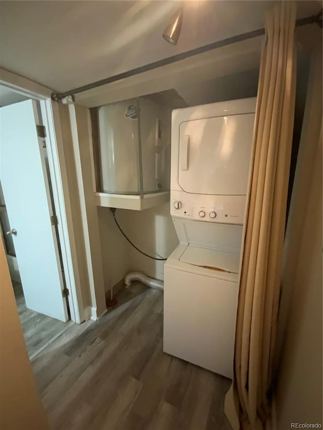 laundry room featuring stacked washer / dryer and hardwood / wood-style floors