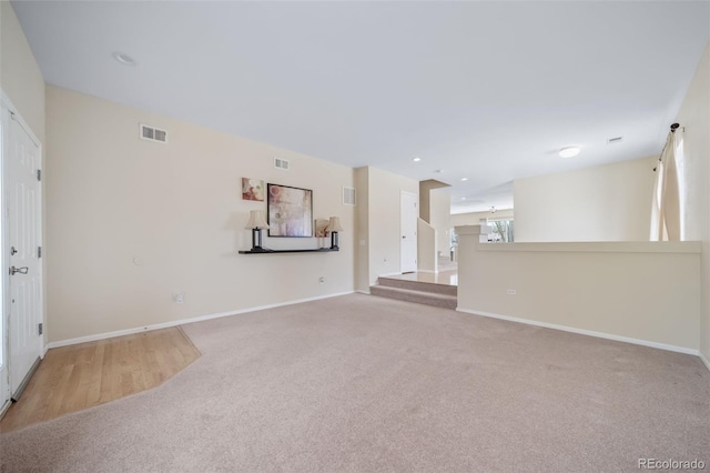 unfurnished living room with carpet floors, baseboards, and recessed lighting
