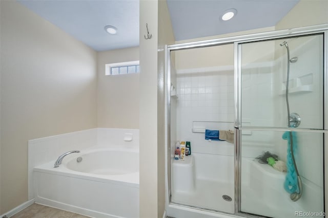 bathroom with a bath and a stall shower