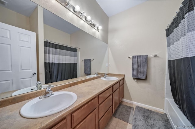 full bathroom with double vanity, baseboards, and tile patterned flooring