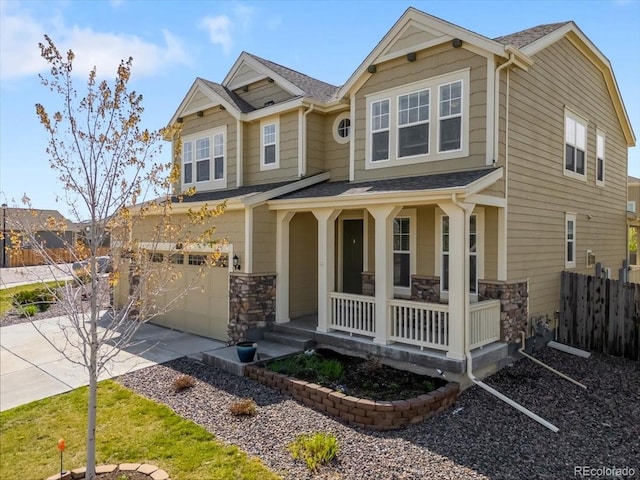 craftsman house featuring fence, covered porch, stone siding, concrete driveway, and an attached garage