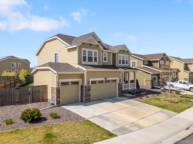 view of front facade with an attached garage, fence, driveway, and stone siding
