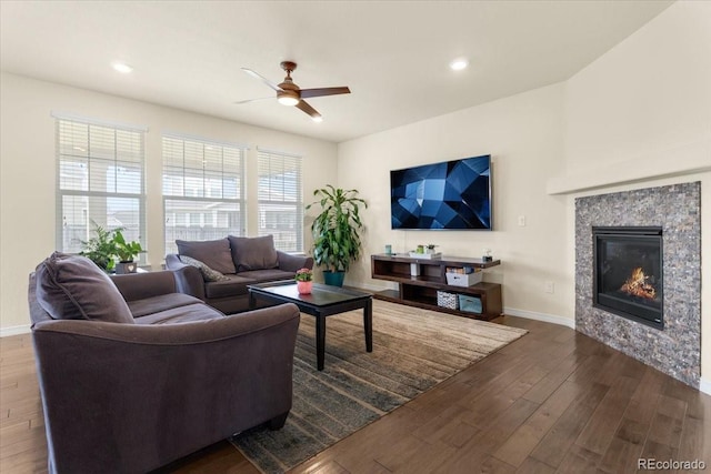 living room featuring baseboards, dark wood-style floors, recessed lighting, a tiled fireplace, and a ceiling fan