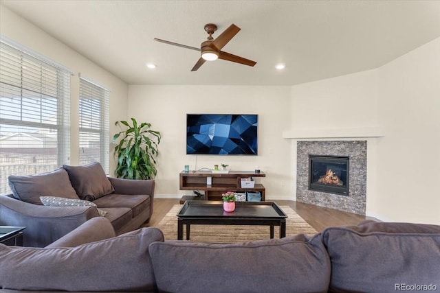 living room with a ceiling fan, baseboards, recessed lighting, and a glass covered fireplace