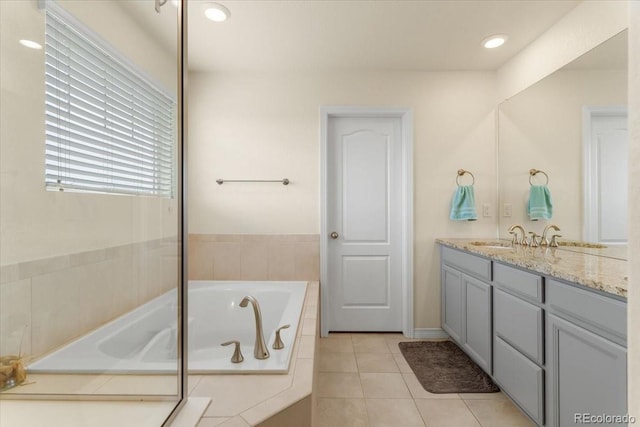 bathroom with recessed lighting, tile patterned floors, a garden tub, and vanity