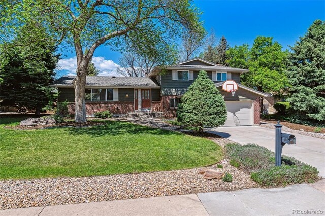 tri-level home featuring concrete driveway, brick siding, a front yard, and a garage