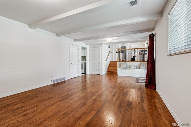 unfurnished living room featuring stairway, beamed ceiling, washer / clothes dryer, wood finished floors, and baseboards