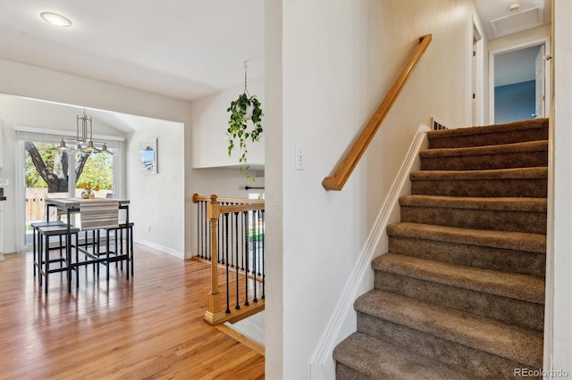 stairs with wood finished floors and baseboards