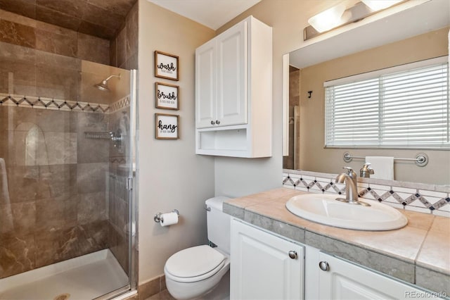bathroom with a stall shower, vanity, and toilet