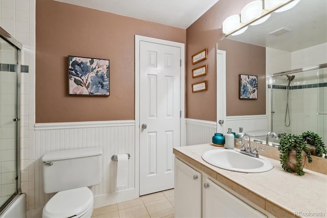 full bathroom featuring wainscoting, toilet, tile patterned floors, and vanity