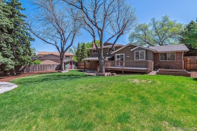 back of house with a deck, brick siding, and a chimney