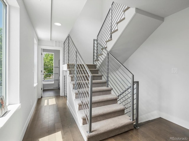 stairs featuring wood-type flooring, baseboards, and recessed lighting