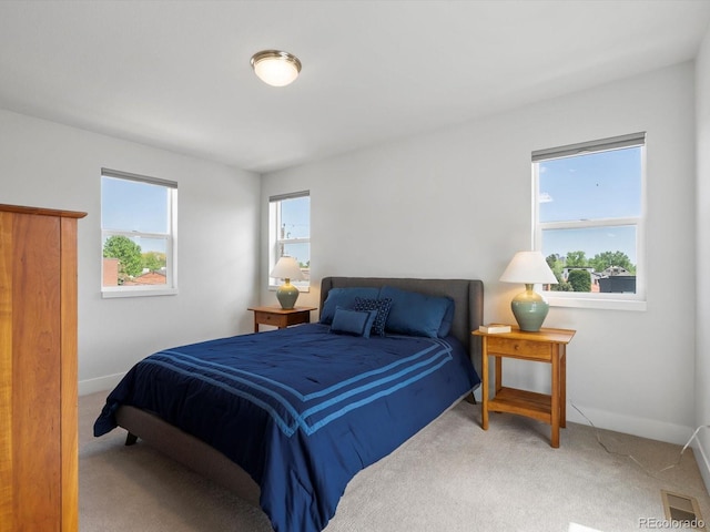 carpeted bedroom with multiple windows and baseboards
