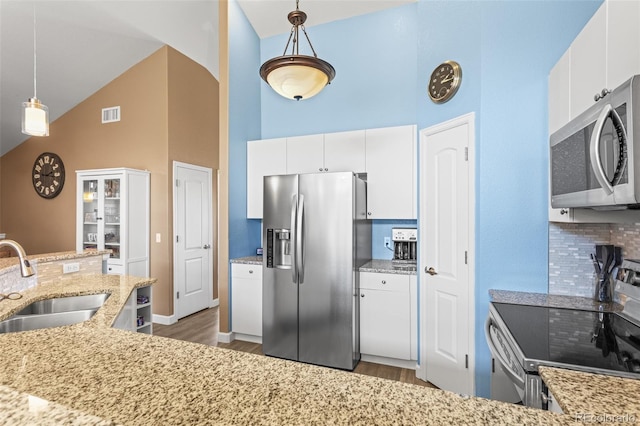 kitchen with appliances with stainless steel finishes, hanging light fixtures, white cabinetry, and sink