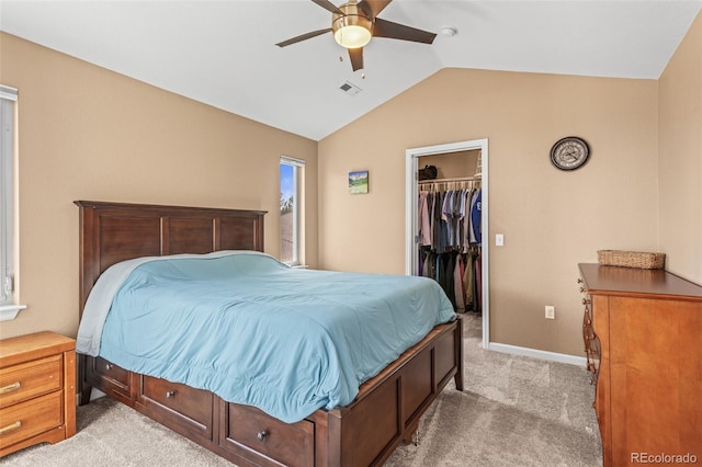 bedroom featuring ceiling fan, lofted ceiling, a walk in closet, a closet, and light colored carpet