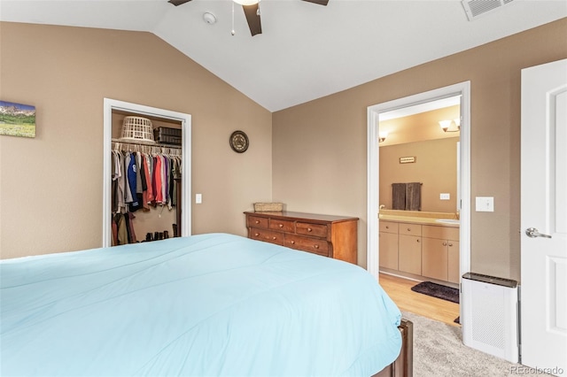 bedroom featuring a closet, lofted ceiling, light hardwood / wood-style flooring, ceiling fan, and ensuite bathroom