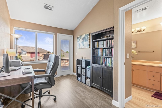 office area featuring vaulted ceiling, sink, and light hardwood / wood-style floors