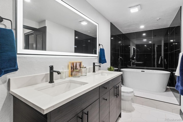 bathroom with tile patterned flooring, vanity, a bathtub, and toilet