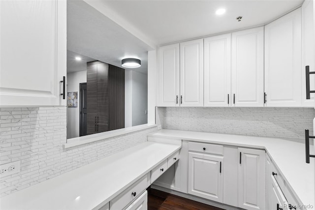 interior space featuring backsplash, dark hardwood / wood-style floors, and white cabinets