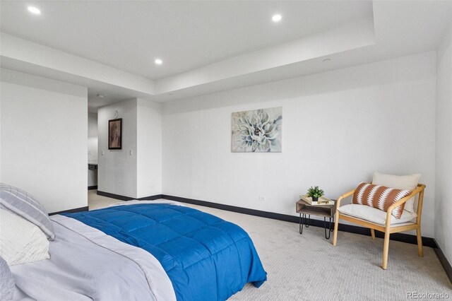 bedroom featuring light carpet and a tray ceiling