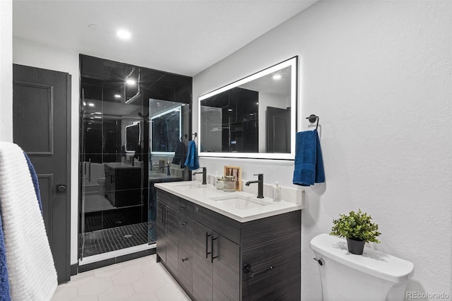 bathroom featuring vanity, tile patterned floors, a shower with door, and toilet