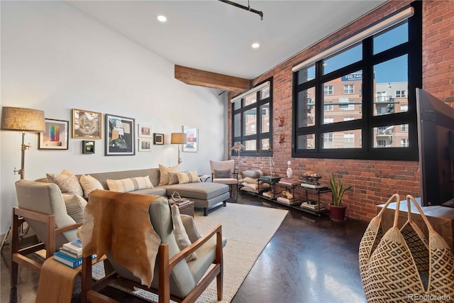 living room featuring finished concrete floors, recessed lighting, and brick wall