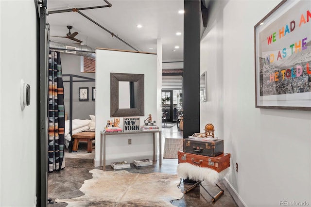 corridor featuring concrete flooring, recessed lighting, and baseboards