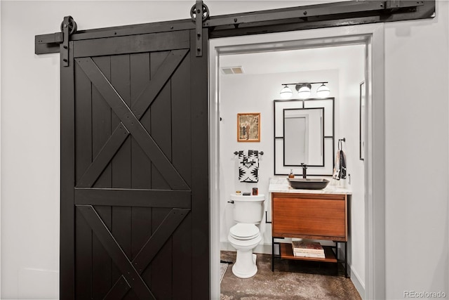 half bath featuring toilet, baseboards, visible vents, and vanity