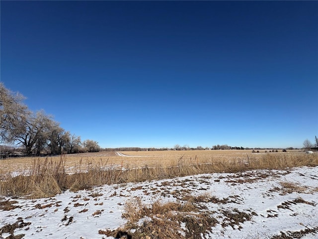 snowy yard featuring a rural view